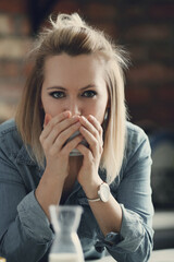 Picture of young blond woman with short hair looking at camera and drinking a cup of tea in the kitchen