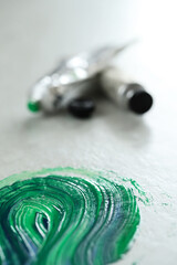 Tube of green paint for painting on a white background