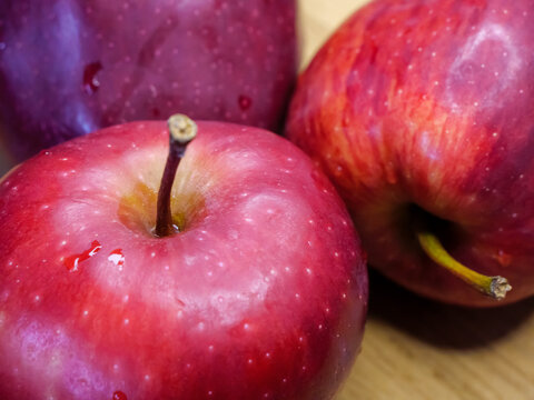Three big red apples, closeup shot. Appetizing fruits, macro.