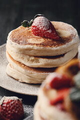 Beautifully decorated delicious sweet pancakes with strawberry on the plate