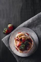 Beautifully decorated delicious sweet pancakes with fruits and honey on the plate