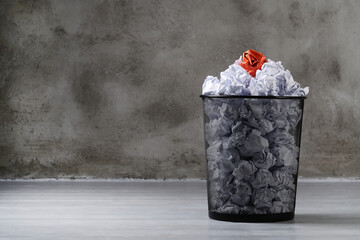 Creased white paper balls with one creased paper ball in a trash can - obrazy, fototapety, plakaty