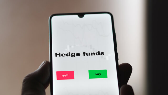 An investor's analyzing the hedge funds etf fund on screen. A phone shows the ETF's prices stocks to invest