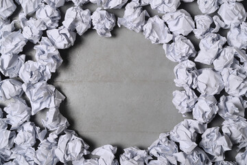 A circle of creased white paper balls against a dark background