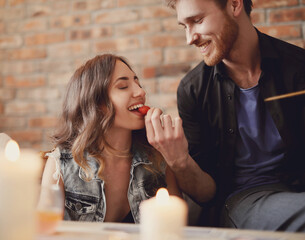 Man gives strawberries to a young woman at home