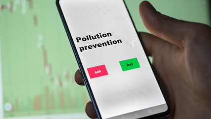 An investor's analyzing the pollution prevention etf fund on screen. A phone shows the ETF's prices stocks to invest