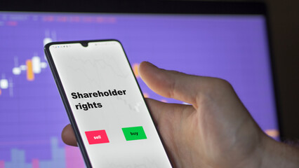An investor's analyzing the shareholder rights etf fund on screen. A phone shows the ETF's prices stocks to invest