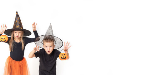 Kids on Halloween. A little girl and a boy in witch and sorcerer costumes in hats holding baskets...