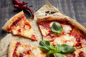 Photo of sliced delicious hot pizza with cheese on parchment paper