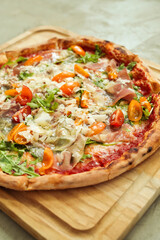 Picture of delicious hot whole pizza with vegetables on a wooden board