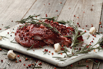 Raw fresh red meat with rosemary and spices