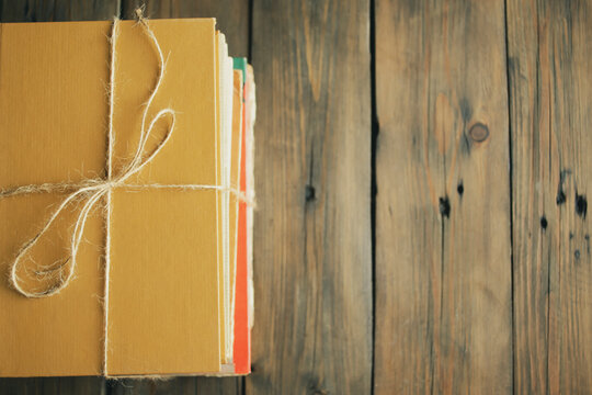 Books are tied with a whip in one pile. Gift books. ON a wooden table is a stack of books tied with a rope.