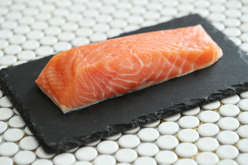 Picture of fresh juicy raw salmon on a black cutting board