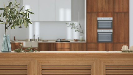 Wooden table top, cabinet, panel or shelf with shutters close up. Olive branch in vase and candles. Blurred background with modern japandi kitchen, wooden cabinets,, interior design