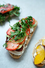 Close view of delicious sweet Bruschetta (sandwiches) with cottage cheese and slices of strawberry on a white background