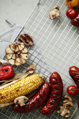 Delicious hot grilled food with sausage,corn and other vegeables on a mesh grid
