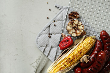 Top view of delicious hot grilled food with sausage,corn and other vegeables on a mesh grid