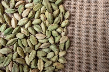 Top View of Dry Cardamom or Cardamon Isolated on Burlap Fabric with Copy Space