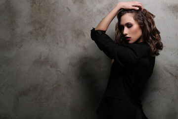 A photo of a young beautiful woman model in black posing for camera