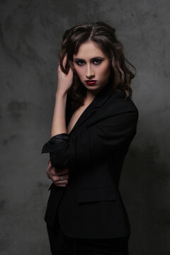 A photo of a young beautiful woman model in black posing for camera