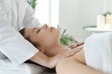 Fototapeta na wymiar Beautician doing neck massage of young beautiful relaxed woman in spa salon