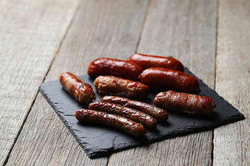 Delicious homemade hot grilled sausage on a wooden black cutting board 