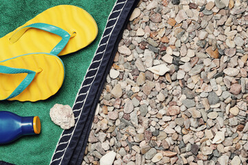 Beach slippers, a bottle of water and a beach towel in shells - obrazy, fototapety, plakaty