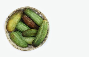 Top View of Organic Cucumber in a Bamboo Basket Isolated on White Background with Copy Space