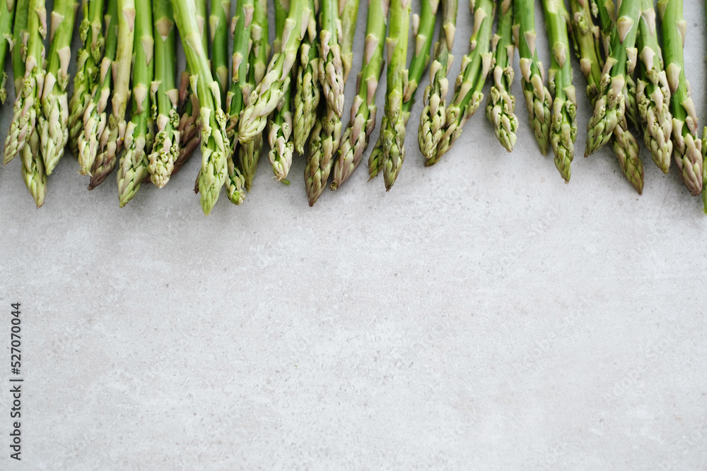 Wall mural overhead view of fresh green asparagus on light surface