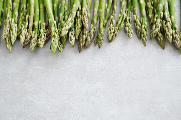 Overhead view of fresh green asparagus on light surface