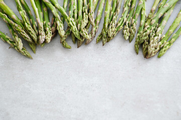 Overhead view of fresh green asparagus on light surface