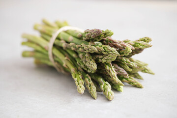 Bunch of fresh spring green asparagus on a light surface