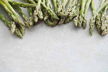 Close up of fresh picked asparagus tips on light slate countertop