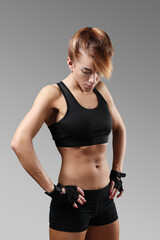 Naklejka premium Sporty beautiful young woman posing with hands on hips on camera