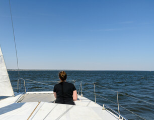 A girl in black clothes on a yacht is resting in the summer. Vacation travel.