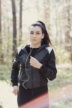 Photo of a young beautiful brunette woman running early in the morning in nature