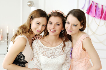 Young , stylish , gorgeous bride with bridesmaids posing for camera on her wedding day