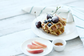 Top view of breakfast of tasty mini Waffles with berries on a white plate