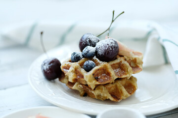 Breakfast of tasty mini Waffles with berries on a white plate
