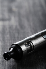 An electronic cigarette for smoking nicotine on a dark wooden background