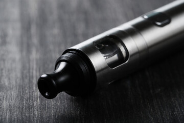 An electronic cigarette for smoking nicotine on a dark wooden background