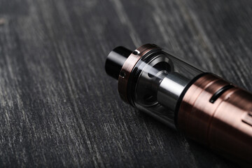 An electronic cigarette for smoking nicotine on a dark wooden background