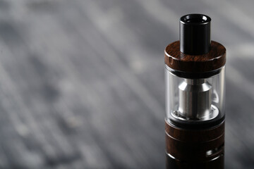 An electronic cigarette for smoking nicotine on a dark wooden background