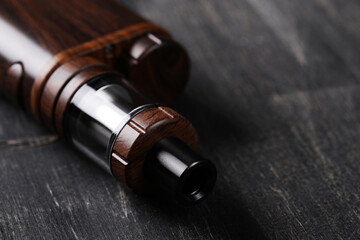 An electronic cigarette for smoking nicotine on a dark wooden background