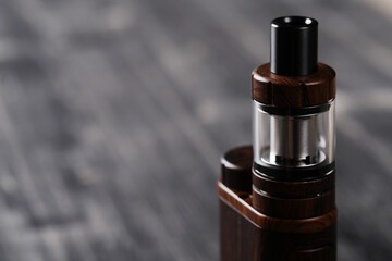An electronic cigarette for smoking nicotine on a dark wooden background