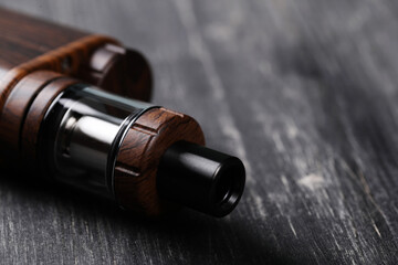 An electronic cigarette for smoking nicotine on a dark wooden background