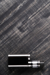 Top view of an electronic cigarette for smoking nicotine on a dark wooden background
