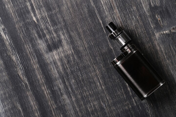 Top view of an electronic cigarette for smoking nicotine on a dark wooden background