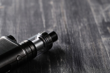 An electronic cigarette for smoking nicotine on a dark wooden background