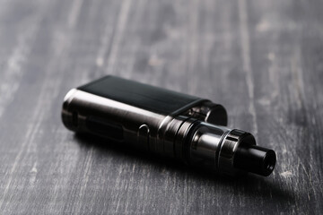 An electronic cigarette for smoking nicotine on a dark wooden background